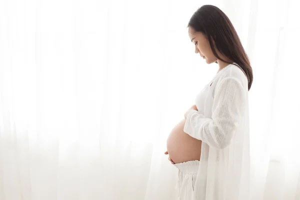 Беременная женщина касается живота. — стоковое фото