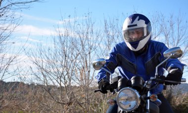 motosiklet kask mavi bir yoldan gidiyor 