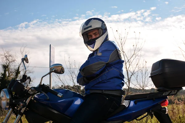 Motorista con casco azul pasando por una carretera —  Fotos de Stock