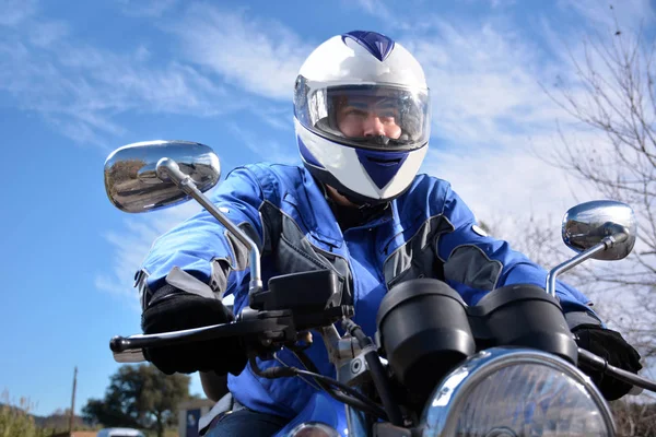 Motorista con casco azul pasando por una carretera —  Fotos de Stock