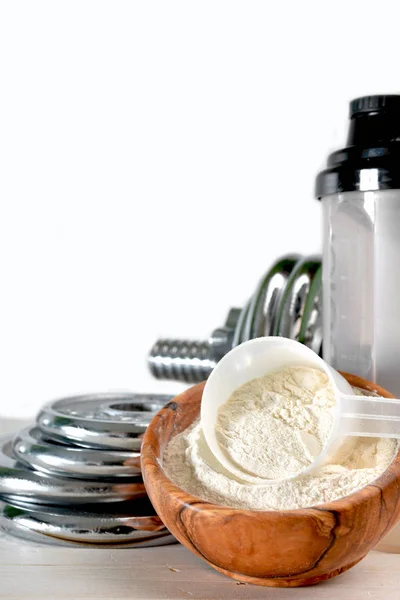 Whey protein taste vanilla with dumbbell — Stock Photo, Image