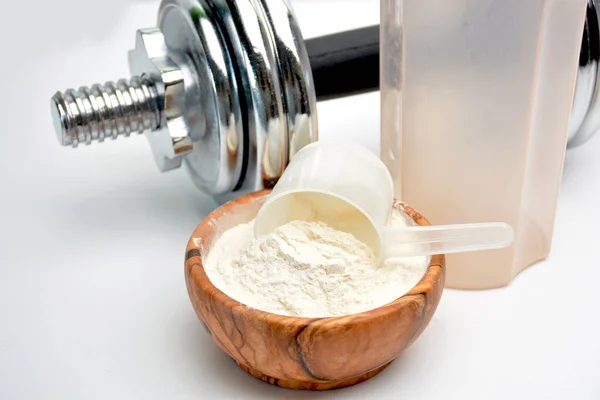 Whey protein taste vanilla with dumbbell — Stock Photo, Image