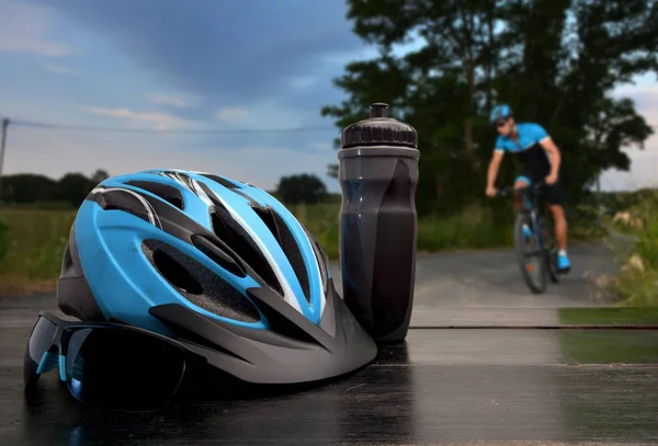 Шлем и солнцезащитные очки велосипедист с дорогой и велосипедист проходит мимо — стоковое фото