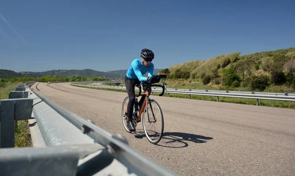 Ciclista formação em uma estrada solitária — Fotografia de Stock
