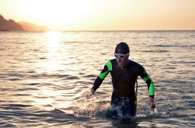 Genç sporcunun triatlon bir gündoğumu önünde 