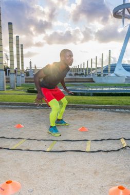 erkek kas eğitim merdiven yere ve koniler.