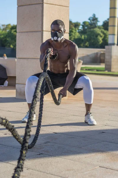 Männliches Muskeltraining mit Kampfseilen und Trainingsmaske — Stockfoto