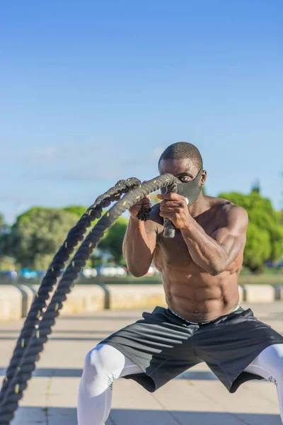 Männliches Muskeltraining mit Kampfseilen und Trainingsmaske — Stockfoto