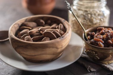 Badem ahşap bir tabak içinde üzümlü 