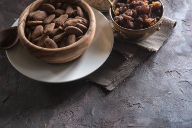 Badem ahşap bir tabak içinde üzümlü 