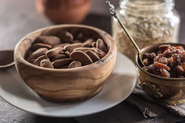 Badem ahşap bir tabak içinde üzümlü 