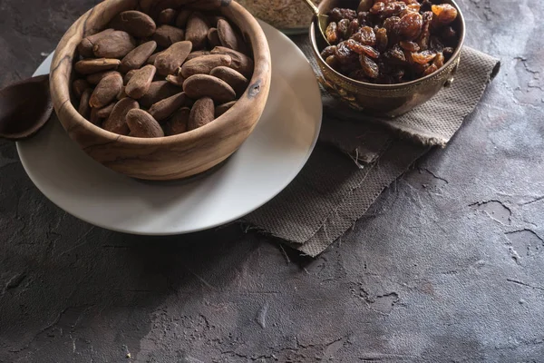 Badem ahşap bir tabak içinde üzümlü 