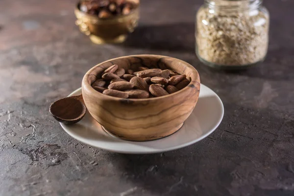 Almond with raisins in a dish of wood — Stock Photo, Image