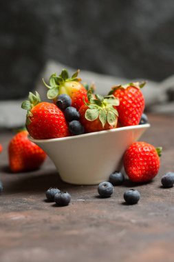 Yaban mersini ve çilek s ile seramik kase dolu