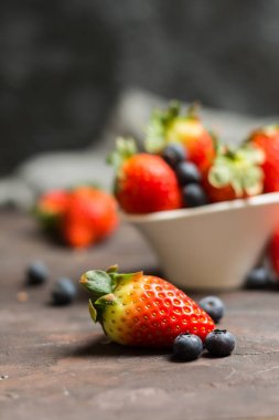 Yaban mersini ve çilek s ile seramik kase dolu