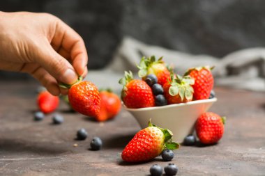 Yaban mersini ve çilek s ile seramik kase dolu