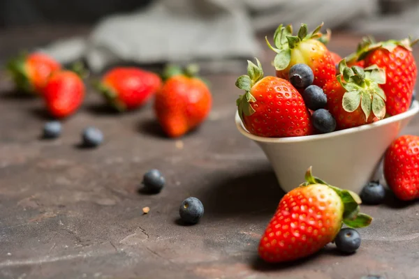 Plein de bol en céramique avec des bleuets et des fraises sur le s — Photo