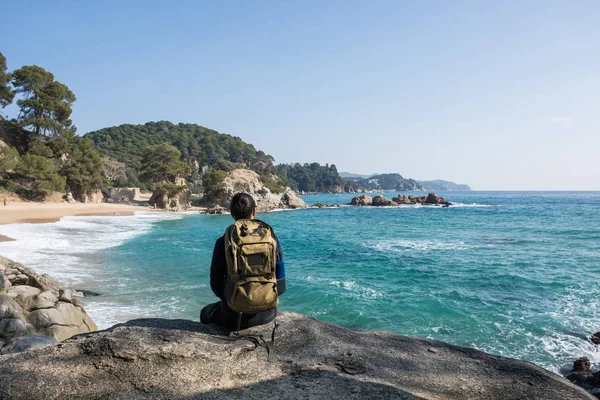 Hombre caminando entre las rocas cerca de un paraíso de playa —  Fotos de Stock