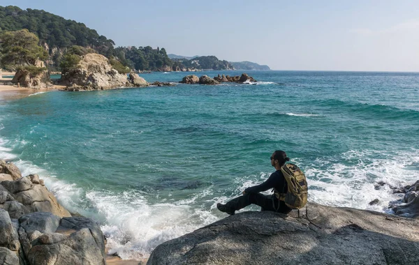 Hombre caminando entre las rocas cerca de un paraíso de playa —  Fotos de Stock