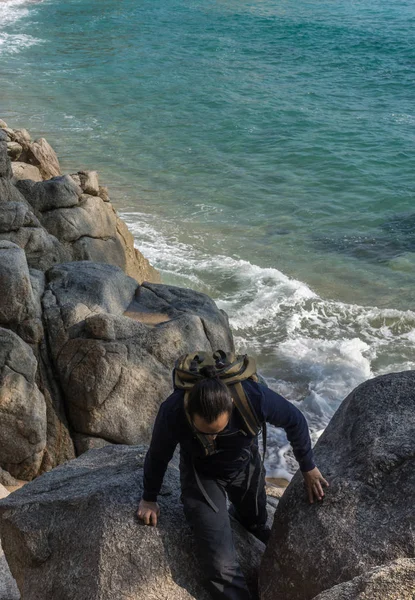 Man walking among the rocks near a beach paradise — Stock Photo, Image