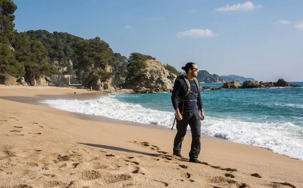 Hombre caminando entre las rocas cerca de un paraíso de playa —  Fotos de Stock