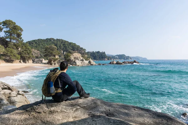 Hombre caminando entre las rocas cerca de un paraíso de playa —  Fotos de Stock