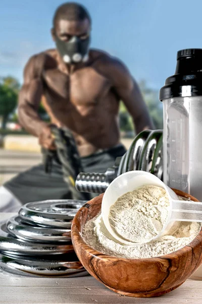 Protein shake Vanilla flavor accompanied by weights and sportsme