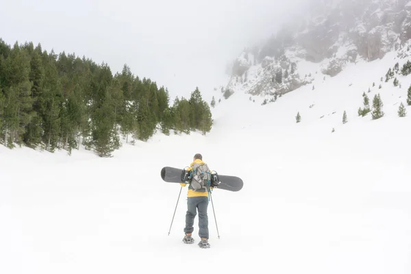 彼のスノーボードで山に登る無料のライダー — ストック写真