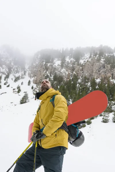 Trittbrettfahrer fährt mit seinem Snowboard den Berg hinauf — Stockfoto