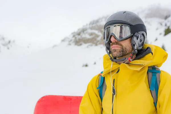 Δωρεάν αναβάτης με χιονοπέδιλα και snowboard στην πλάτη του. — Φωτογραφία Αρχείου