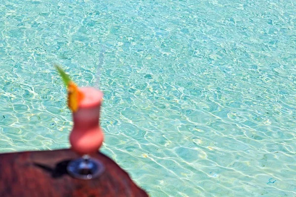 Glas mit Getränken steht auf einem Strandtisch — Stockfoto