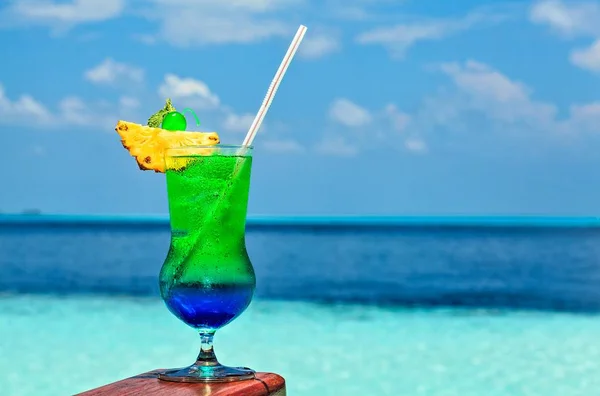 Glass of drink is on a beach table — Stock Photo, Image
