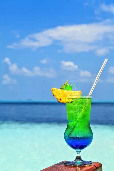 Un vaso de bebida está en una mesa de playa —  Fotos de Stock