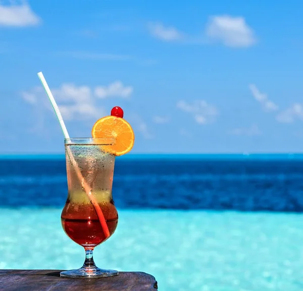 Il bicchiere di bevanda è su un tavolo da spiaggia Foto Stock