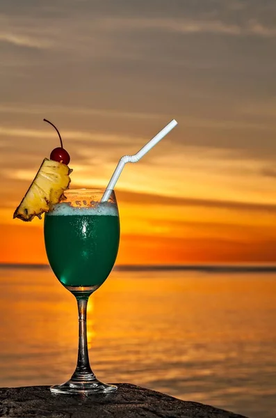 Un vaso de bebida está en una mesa de playa — Foto de Stock