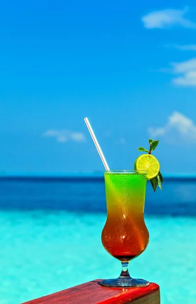 Glass of drink is on a beach table — Stock Photo, Image