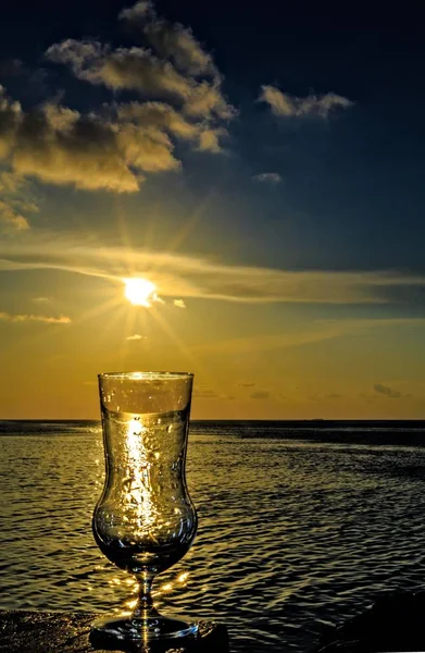 Стакан напитка на пляжном столе — стоковое фото