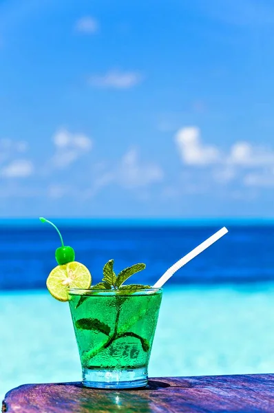 Glas van drank is op een strand-tabel — Stockfoto