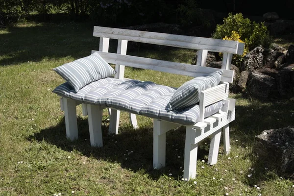 Bahçedeki rektal paletlerle yapılmış beyaz koltuk..