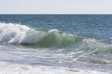 Güzel bir deniz dalgası kırılıyor ve hoş renkler yaratıyor.