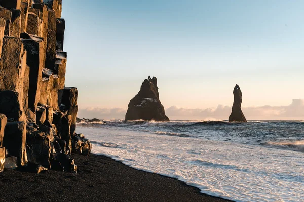 Playa de arena negra muy conocida en la ciudad de Vik en Islandia durante la puesta del sol de invierno. Paisaje islandés hermoso, turismo, paisaje dramático — Foto de Stock