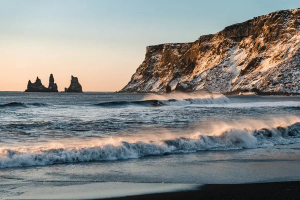 Playa de arena negra muy conocida en la ciudad de Vik en Islandia durante la puesta del sol de invierno. Paisaje islandés hermoso, turismo, paisaje dramático — Foto de Stock