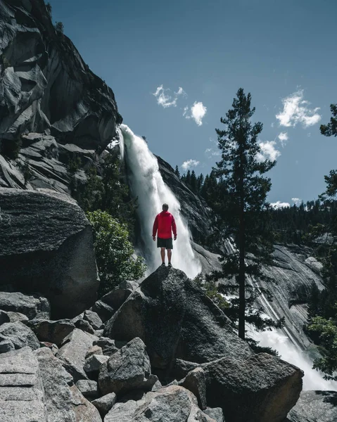 Um tipo aventureiro em frente a uma enorme cascata no Vale de Yosemite. Pessoas que se aventuram. Fotografia de formato Instagram — Fotografia de Stock