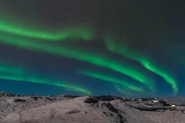在冰岛上空，有一道美丽的北极光也叫北极光。斯堪的纳维亚半岛的冬季非常迷人，吸引了许多来自世界各地的游客参观 — 图库照片