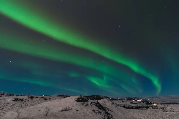 在冰岛上空，有一道美丽的北极光也叫北极光。斯堪的纳维亚半岛的冬季非常迷人，吸引了许多来自世界各地的游客参观 — 图库照片