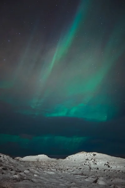 A beautiful northern lights also called Aurora Borealis over the Iceland. Winter time in Scandinavia is very magical and brings a lot of tourists from all over the world to see it — Stock Photo, Image