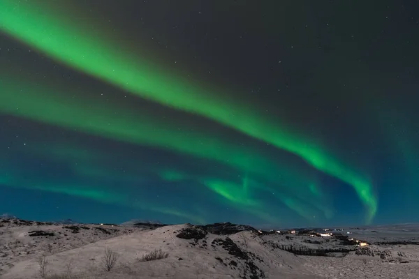 Красиве північне сяйво над Ісландією також називається Aurora Borealis. Зимовий період у Скандинавії є дуже магічним і приносить багато туристів з усього світу, щоб побачити його. — стокове фото