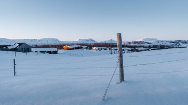 İzlanda 'da kış harikalar diyarı. Fotoğraf, altın saat boyunca İzlanda 'nın donmuş köylerinden birini gösteriyor. İzlanda 'da turizm. Yılın herhangi bir zamanında İzlanda 'yı ziyaret et