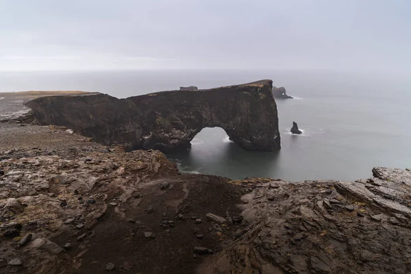 Una famosa roca llamada Dyrholaey se encuentra en Islandia, cerca de la ciudad de Vik. Esta roca es un objetivo muy popular para los fotógrafos en cualquier condición climática — Foto de Stock