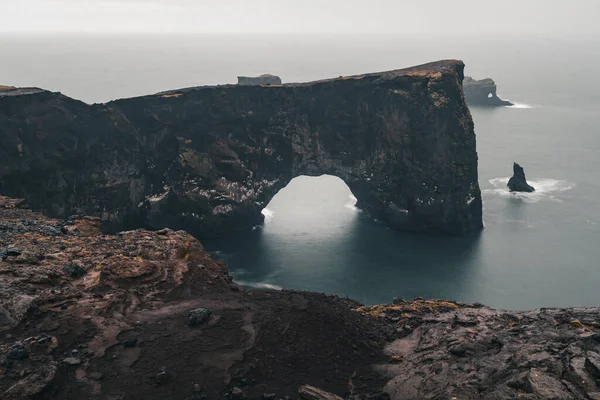 Una famosa roca llamada Dyrholaey se encuentra en Islandia, cerca de la ciudad de Vik. Esta roca es un objetivo muy popular para los fotógrafos en cualquier condición climática — Foto de Stock